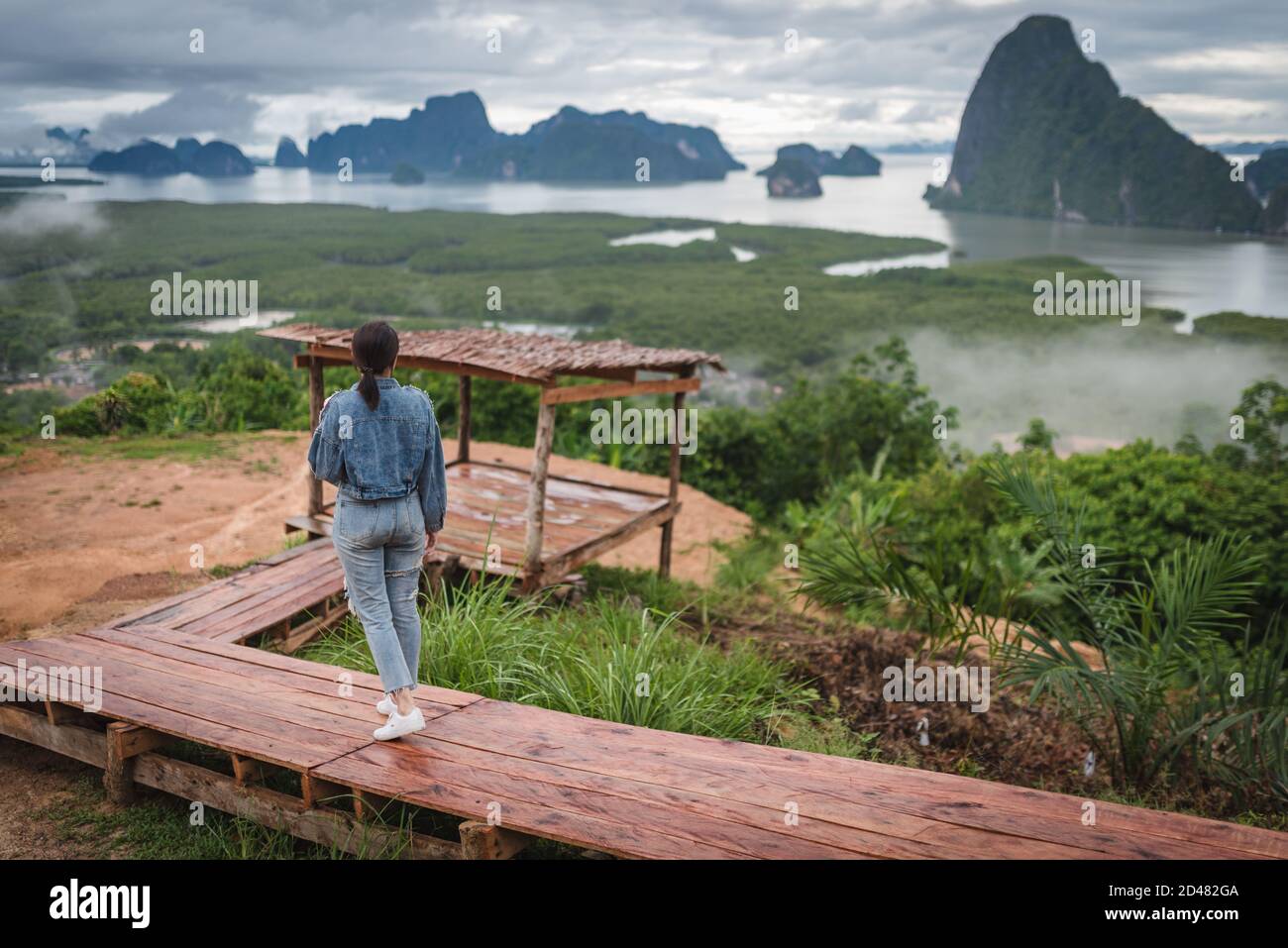 Le paysage d'une femme voyageur marchant sur le chemin en bois qui regarde l'île de Sametnangshe dans la matinée dans la province de Phang-nga, en Thaïlande. Banque D'Images