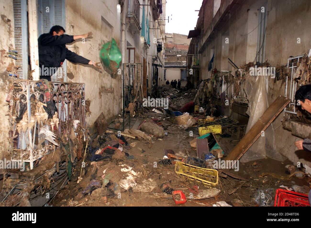 A resident of the popular Bab el Oued neighbourhood in Algiers cleans his  house in a devastated street November 13, 2001. Algeria's worst floods in  nearly 40 years have killed at least