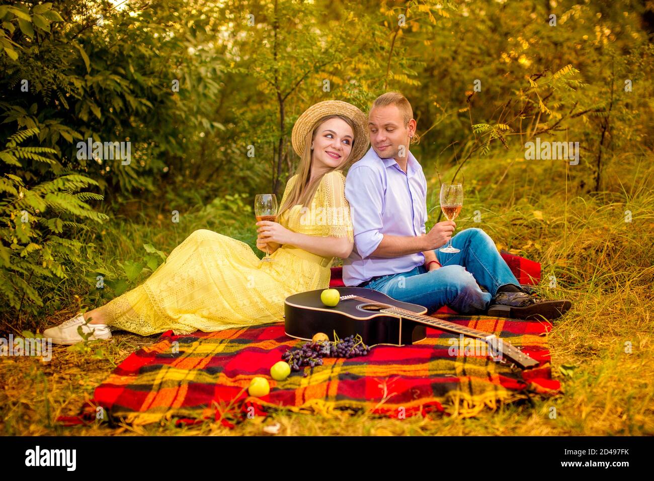 Image d'un couple amoureux ayant un pique-nique avec verres de vin dans le parc Banque D'Images