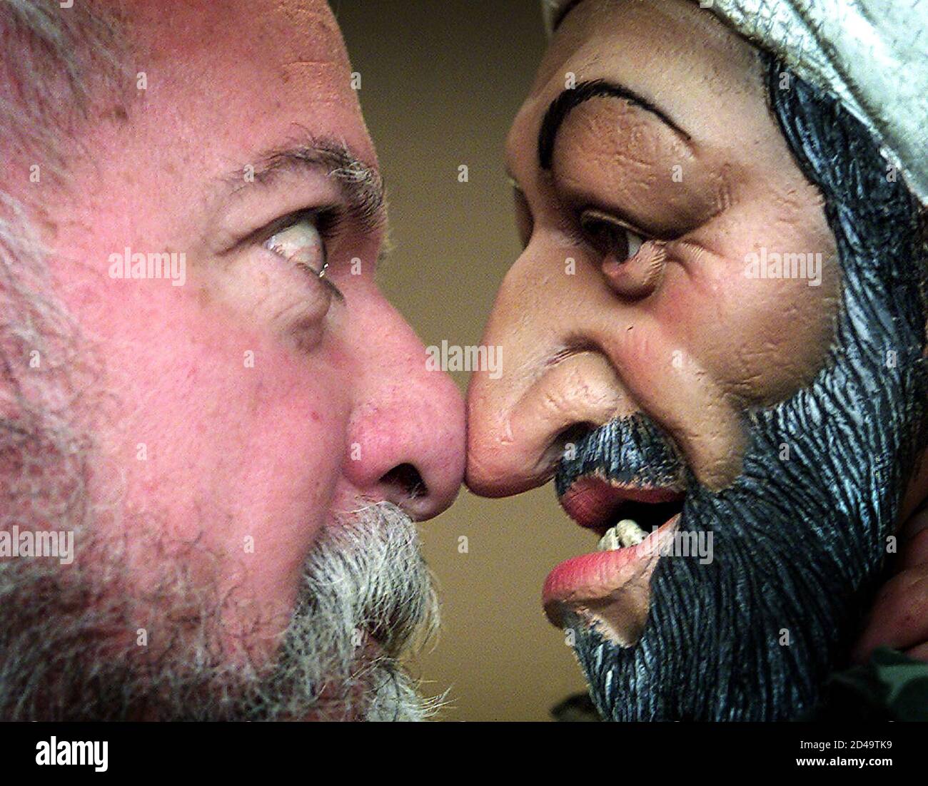 A puppet of Osama bin Laden comes face to face with its creator Roger Law  at the Sotheby's auction house at Olympia in central London, November 23  2001. The puppet has been