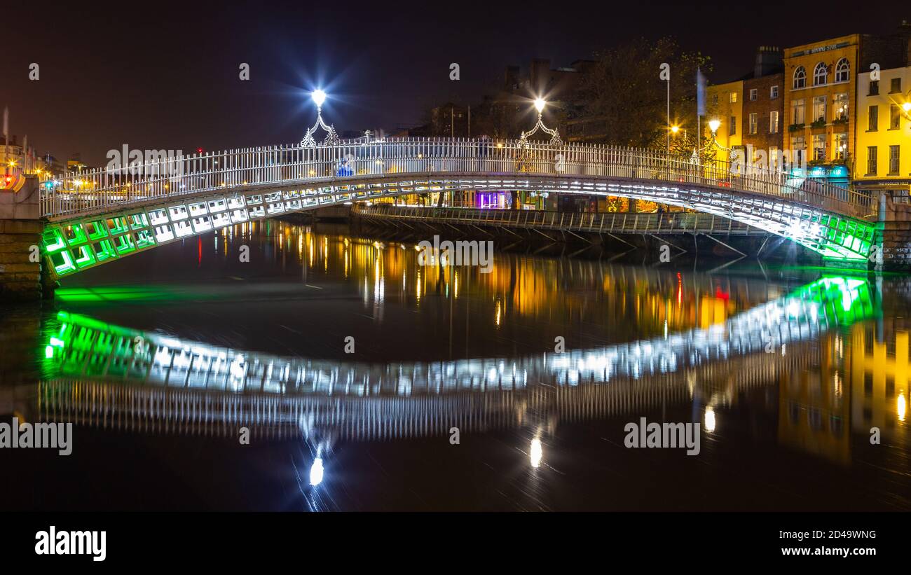 Dublin, Irlande - 08 novembre 2015 : Happeny Bridge, un pont piétonnier caractéristique du XIXe siècle au-dessus de la rivière Liffey la nuit. Illuminati coloré Banque D'Images