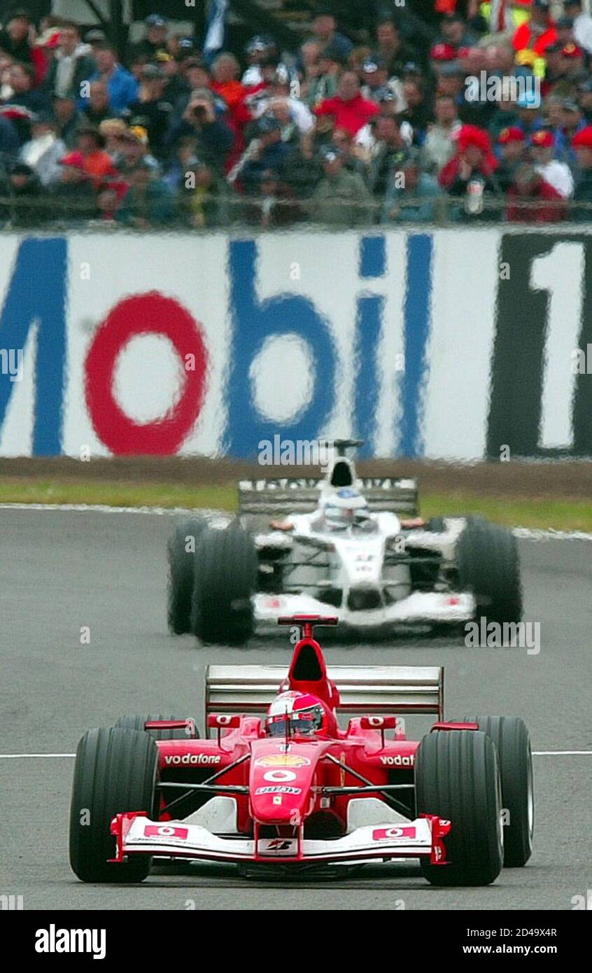 Michael Schumacher, le pilote allemand de Ferrari, passe devant Olivier  Panis, le pilote français DU BAR, pour remporter le Grand Prix britannique  à Silverstone, le 7 juillet 2002. Schumacher a terminé dimanche