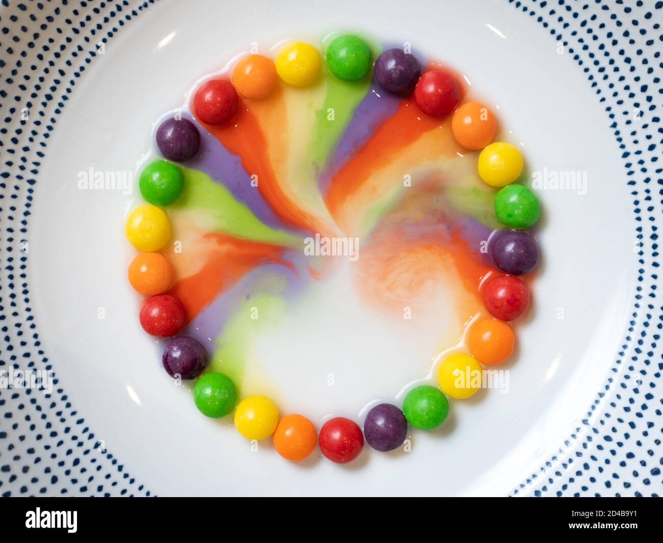 Un cercle de petits bonbons dans un bol blanc avec les couleurs se sont lentement affichées au milieu Banque D'Images