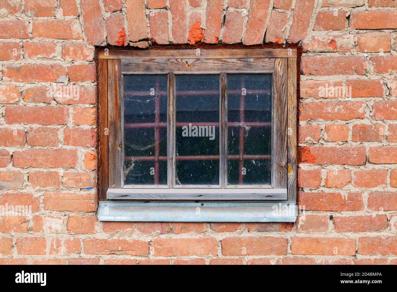 Ancienne fenêtre verrouillée avec grille de protection en métal dans un mur de brique grundy, texture de photo d'arrière-plan Banque D'Images