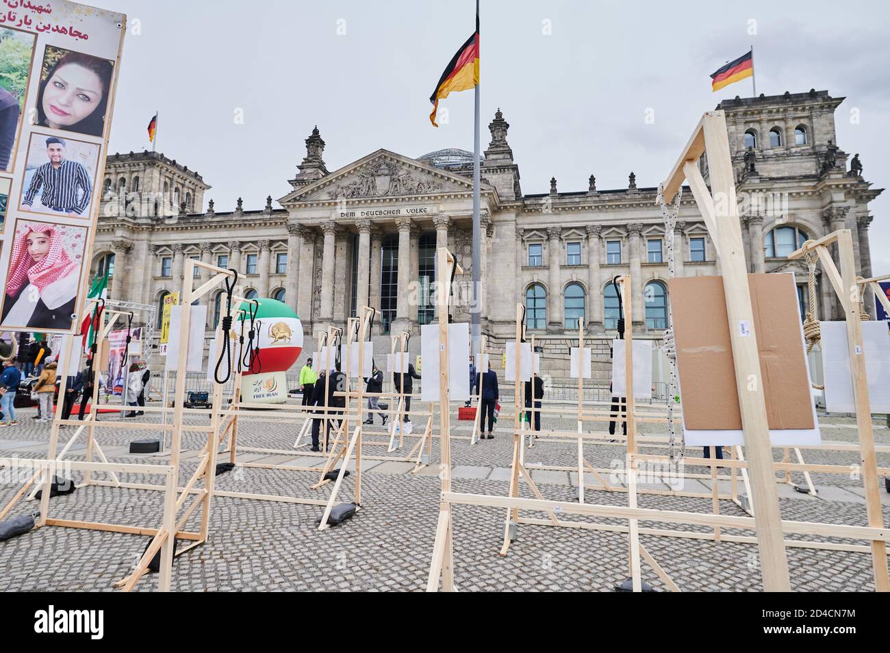 08 octobre 2020, Berlin: Des manifestants sont accrochés symboliquement sur un girlette devant le Reichstag. La communauté iranienne en exil se manifeste devant le Reichstag peu avant la Journée mondiale contre la peine de mort, le 10.10.2020. Entre autres choses, ils ont érigé 40 gupermettre avec des images de personnes. Ce sont les photos des personnes actuellement condamnées à mort en Iran et en attente d'exécution. Avec le rassemblement de protestation, le Conseil national de résistance de l'Iran (NWRI) appelle à un arrêt des massacres des manifestants et à souligner le danger urgent de l'exécution de la p politique Banque D'Images