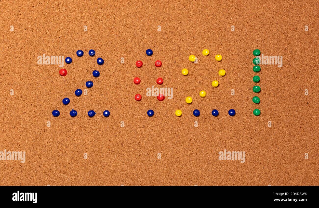 Le numéro 2021 du nouvel an est composé de broches en papier bleu, rouge, jaune et vert sur un panneau d'affichage en liège marron. Banque D'Images