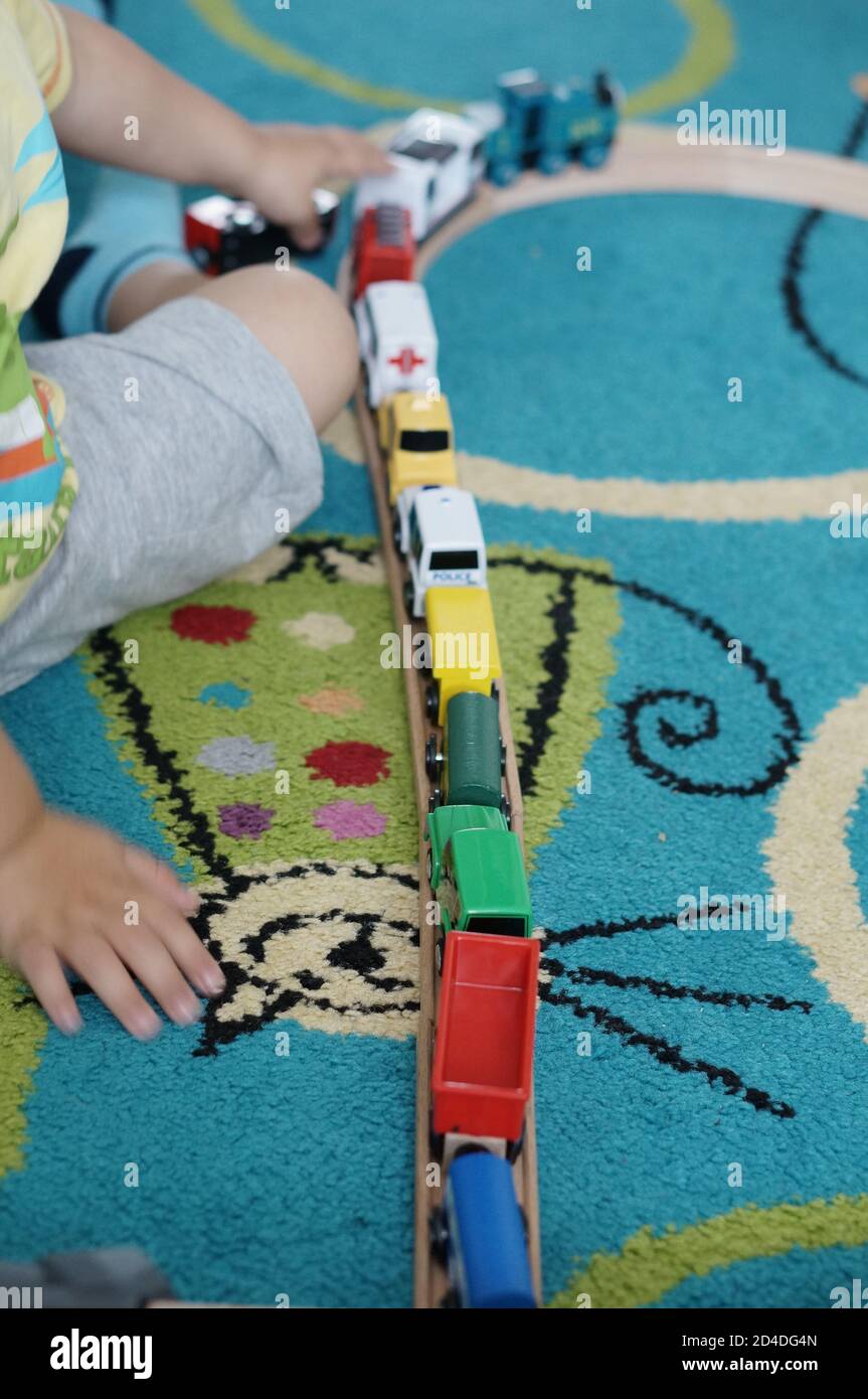 Plan vertical d'un enfant jouant avec un train à vapeur jouet Banque D'Images