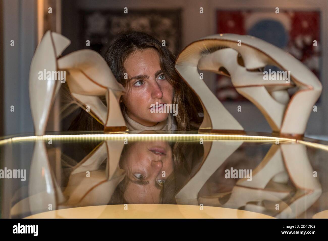 Londres, Royaume-Uni. 9 octobre 2020. Un membre du personnel voit des œuvres de Jimmy Junichi Sugiura, un designer de chaussures sculpturales, lors du lancement de la Maison des bandits à Mayfair – un nouvel espace d'art et de mode de la Fondation Sarabande. La Fondation, établie par feu Lee Alexander McQueen, soutient et promeut le talent créatif. Les œuvres d'une sélection des 100 artistes et designers que la Fondation a soutenu jusqu'à présent sont présentées dans ce nouveau magasin et galerie temporaire sur la rue Vigo, à côté du magasin Burberry Regent Street. L'ouverture coïncide avec la semaine de la Frise et se déroule jusqu'à Noël. CRED Banque D'Images