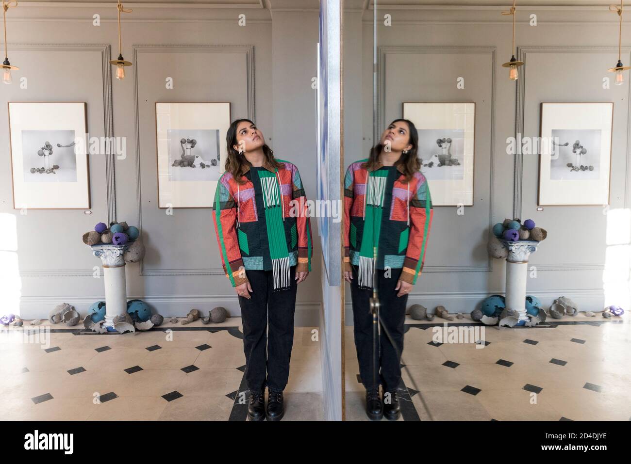 Londres, Royaume-Uni. 9 octobre 2020. Un membre du personnel en face des œuvres de l'artiste visuel Paloma Tendero au lancement de la Maison des bandits à Mayfair – un nouvel espace d'art et de mode par la Fondation Sarabande. La Fondation, établie par feu Lee Alexander McQueen, soutient et promeut le talent créatif. Les œuvres d'une sélection des 100 artistes et designers que la Fondation a soutenu jusqu'à présent sont présentées dans ce nouveau magasin et galerie temporaire sur la rue Vigo, à côté du magasin Burberry Regent Street. L'ouverture coïncide avec la semaine de la Frise et se déroule jusqu'à Noël. Crédit : Stephen Chu Banque D'Images