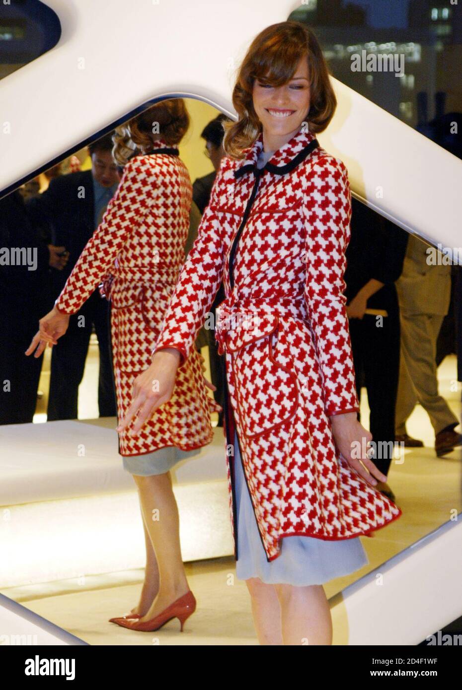 L'actrice d'origine ukrainienne Milla Jovovich tente un manteau Prada lors  d'une fête de pré-ouverture à Tokyo le 6 juin 2003. Le magasin sera ouvert  par le Directeur général du Groupe Prada, Patrizio