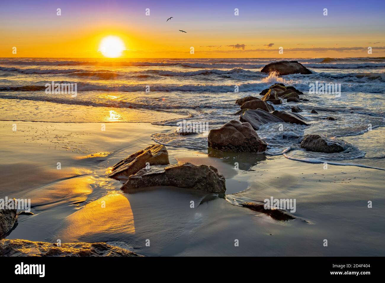 Lever de soleil avec vagues éclaboussant sur les rochers, Narragansett Beach, Rhode Island USA Banque D'Images