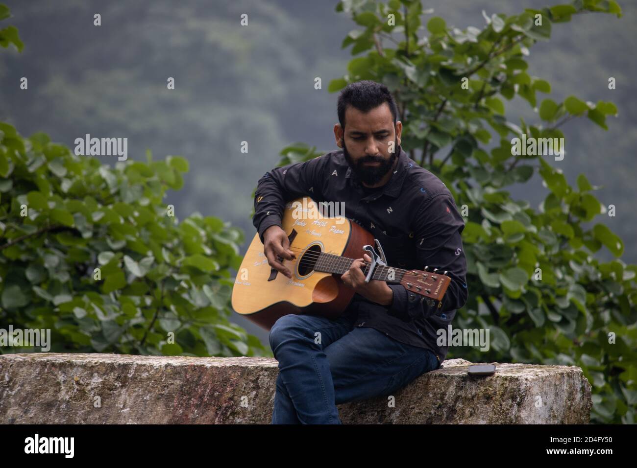Dehradun, Uttarakhand/India-September 12 2020:UN jeune jouant de la guitare dans de belles collines. Banque D'Images