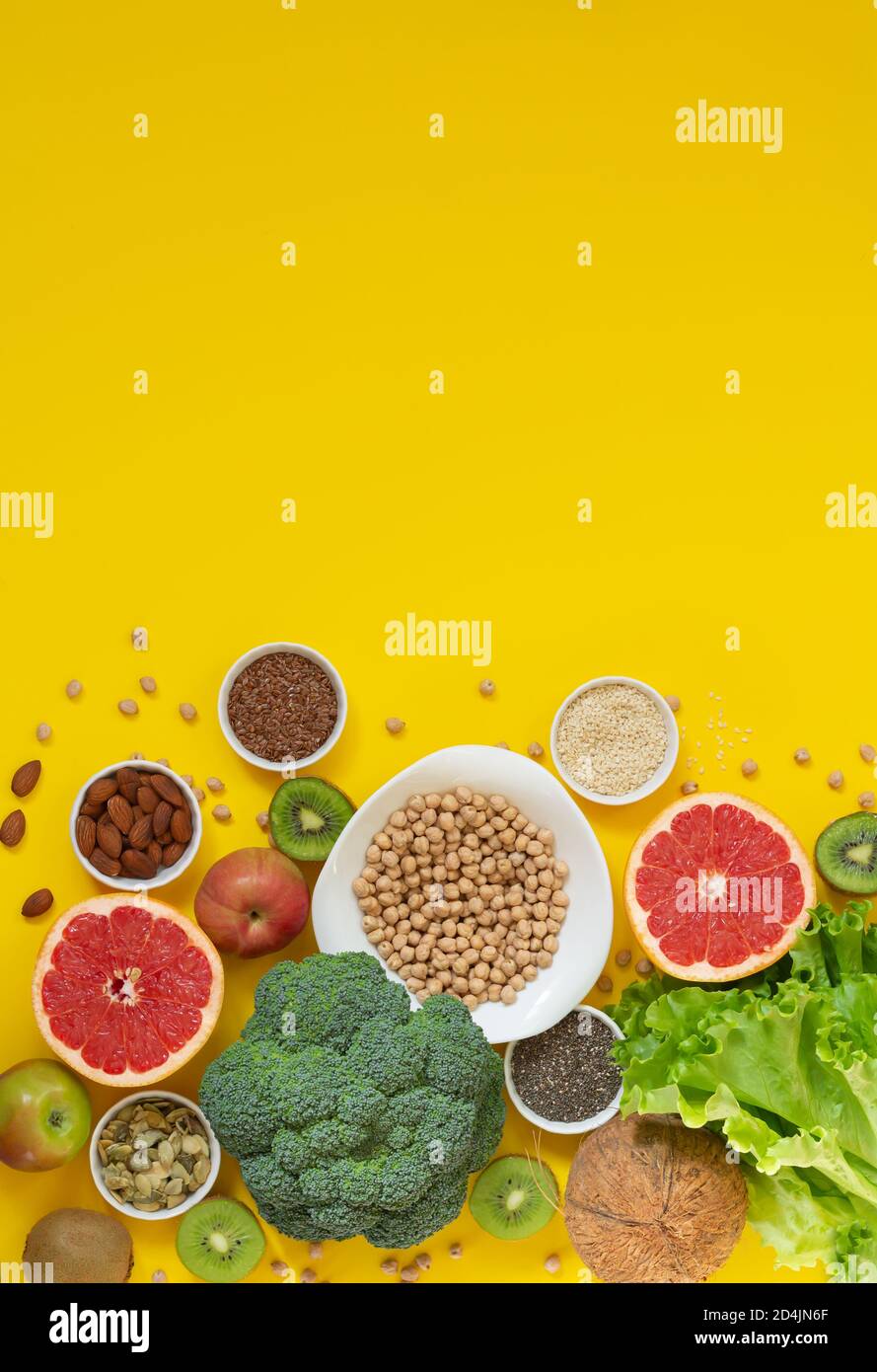 Sélection de nourriture saine et saine (légumes, fruits, graines, noix, herbes) sur fond jaune avec espace de copie Banque D'Images