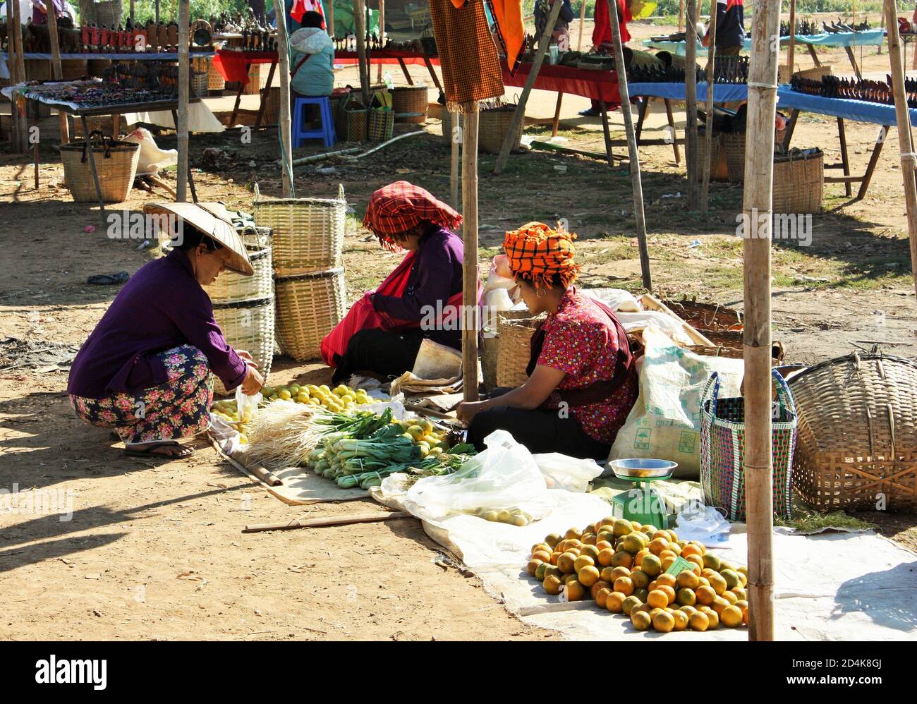 Lac Inle, État de Shan / Myanmar - 18 décembre 2019: Les gens de l'ethnie Pa'O locale portant des vêtements traditionnels dans une cabine de légumes au marché de Phaung Daw Oo Banque D'Images