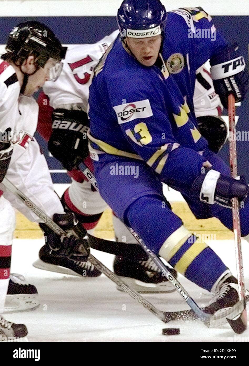 Tapis Sundin (R) de Suède tente de repousser un palet au-delà de la Suisse Beat Forster (L) lors de leur match de qualification au championnat du monde de hockey sur glace à Turku, le 6 mai 2003. La Suède a affrontée le match 5-2. REUTERS/Alexander Demianchuk AD Banque D'Images
