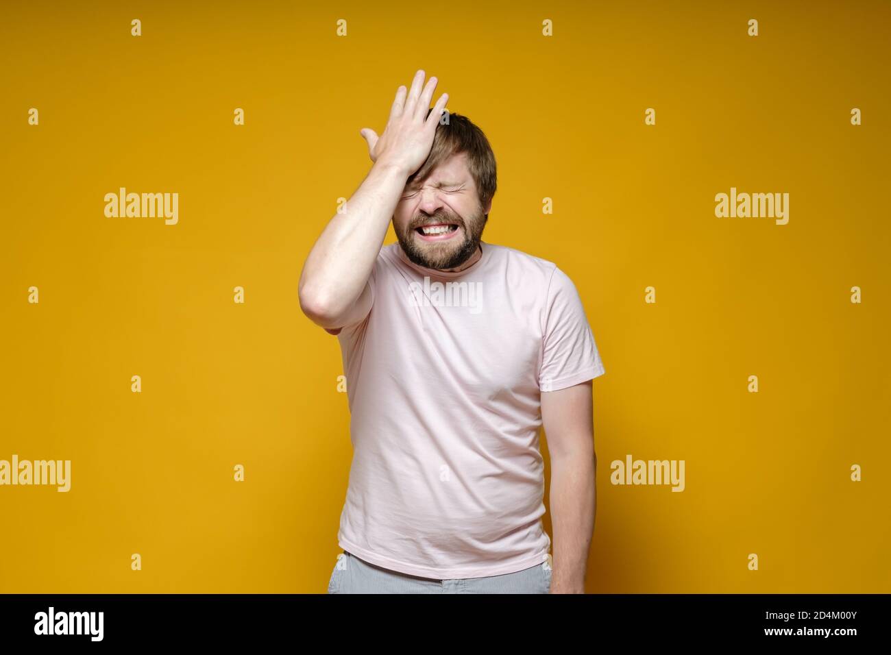 Malheureux barbu homme a oublié quelque chose, il tient frustré main sur le front essayant de se rappeler, fermant les yeux et les dents de grincer. Banque D'Images