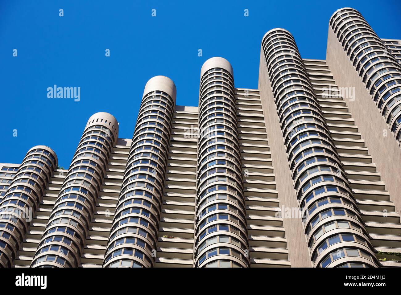 La façade cannelée avec baies vitrées est et la conception inhabituelle d'un immeuble d'appartements, se distingue contre le ciel bleu clair Banque D'Images