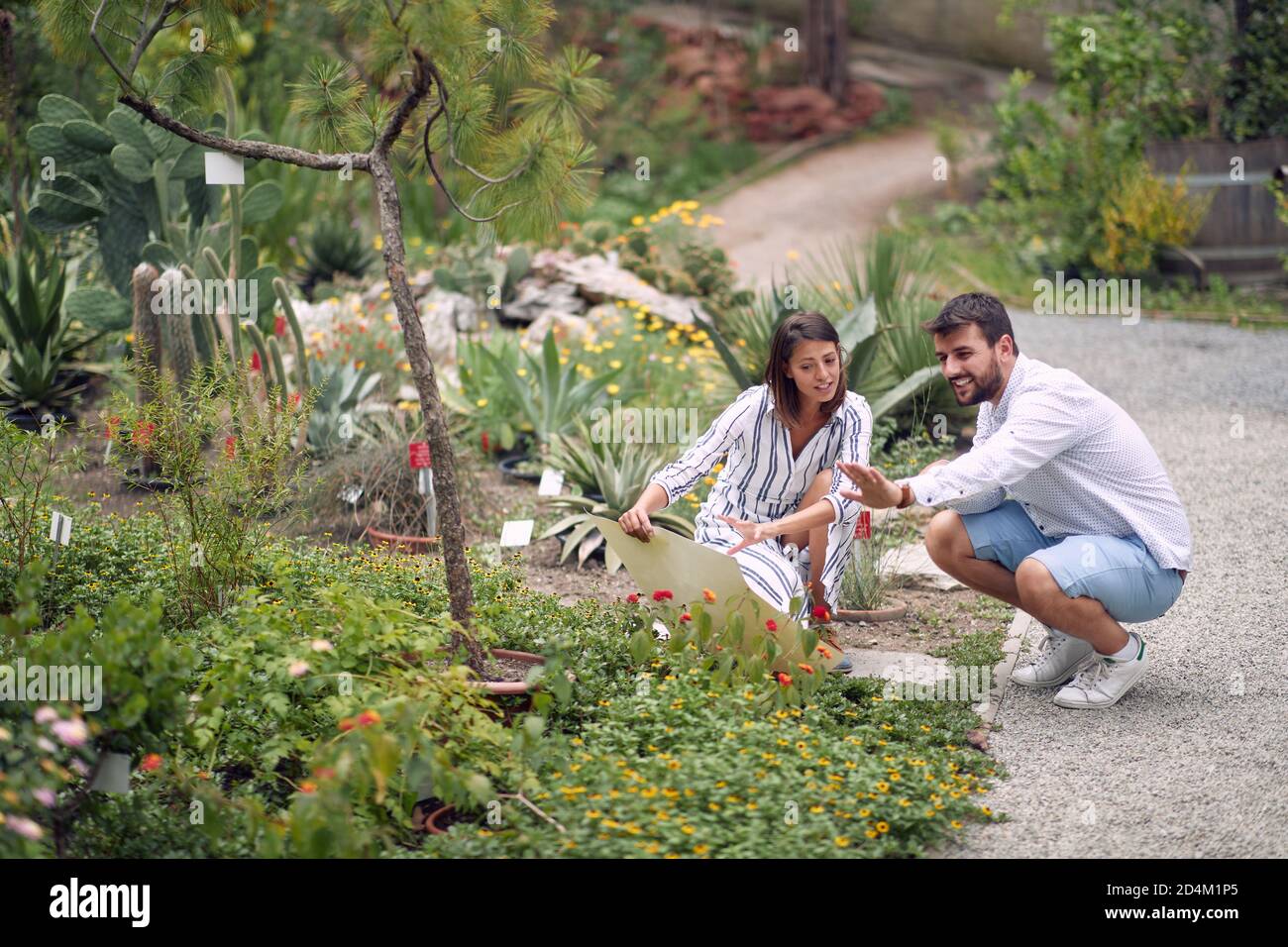 Visiteur mâle et guide femelle étudiant les plantes à la botanique jardin Banque D'Images