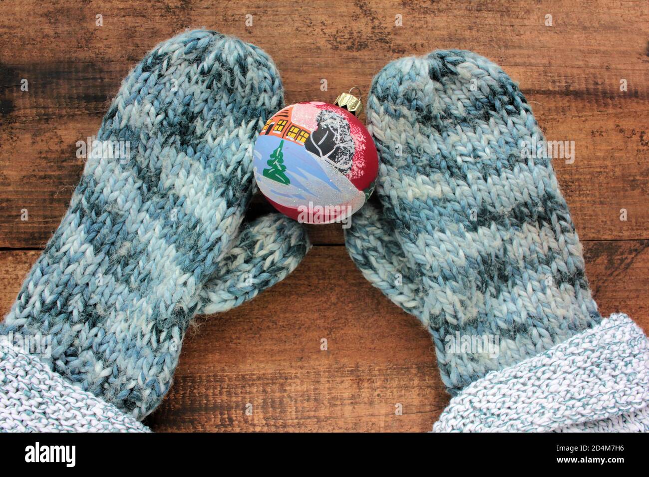 Femme mains dans les moufles tenant la décoration de boule de noël sur fond  de table vintage. Vue de dessus. Style de pose à plat. Copier l'espace  Photo Stock - Alamy