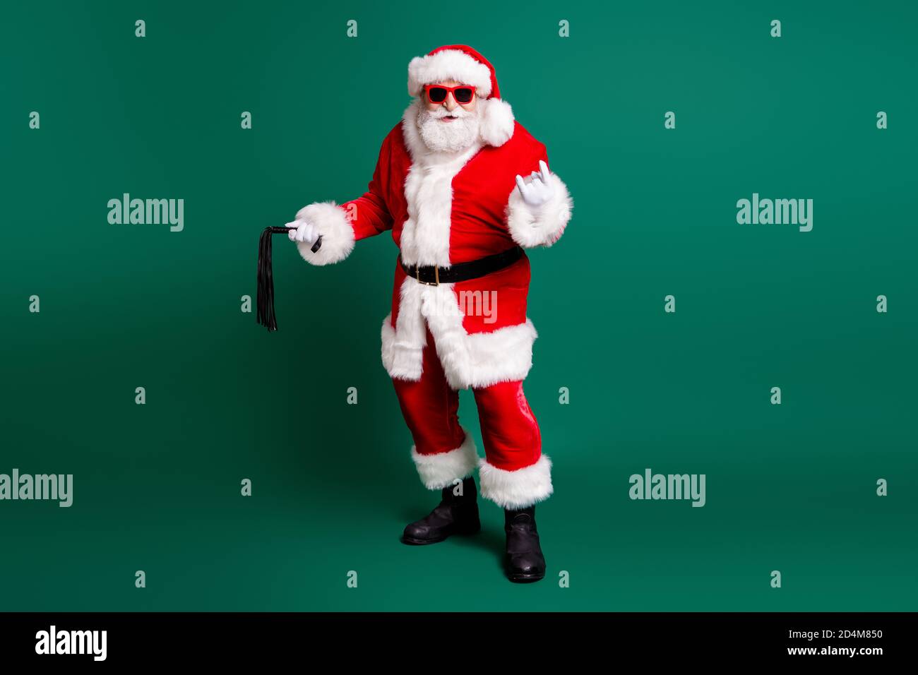 Vue sur toute la longueur de la taille du corps de sa belle graisse Un père père de père de père de père de père de père de père barbu froid en surpoids tenant les mains fouet montrant symbole corne pour des vacances festives Banque D'Images