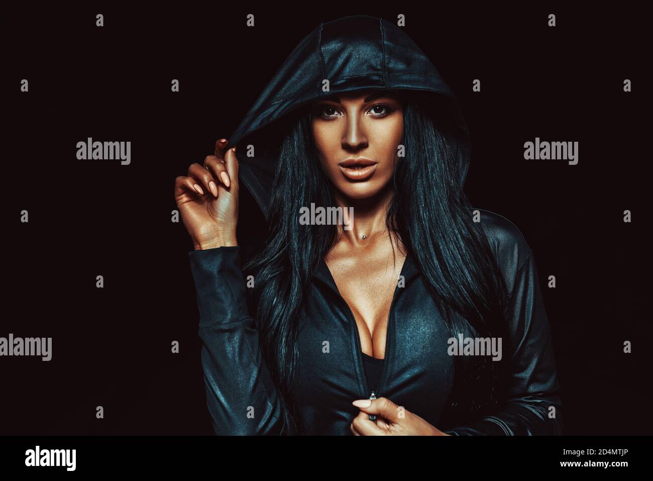 Jeune femme sexy brune en capot sombre portrait de nuit Banque D'Images