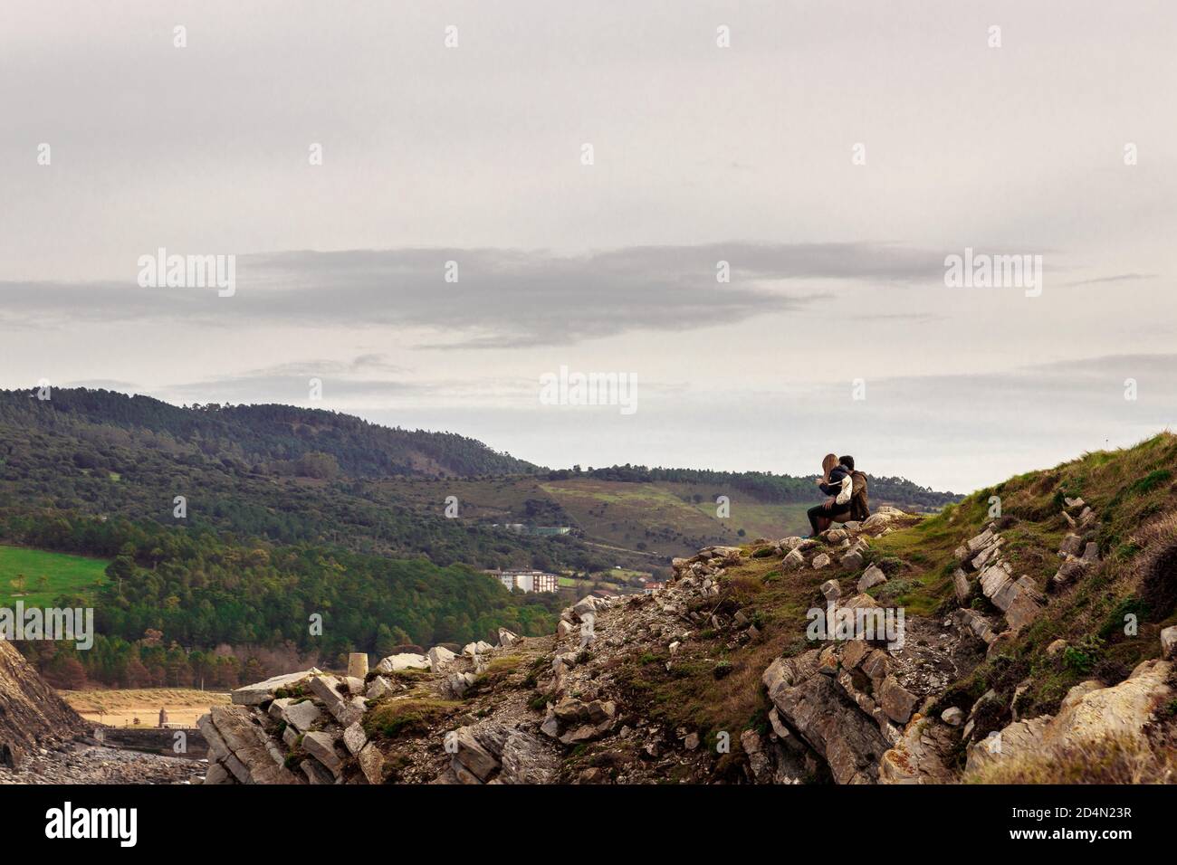 Couple de randonneurs aventureux et romantique assis sur les rochers et regardant à la montagne Banque D'Images