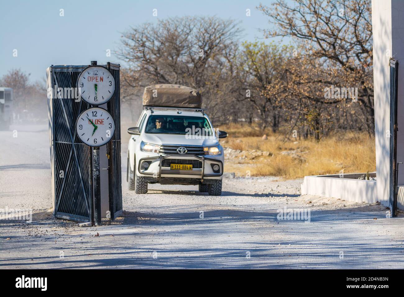 Entrée au camp de halali, avec heures d'ouverture et de fermeture marquées, Parc national d'Etosha, Namibie Banque D'Images