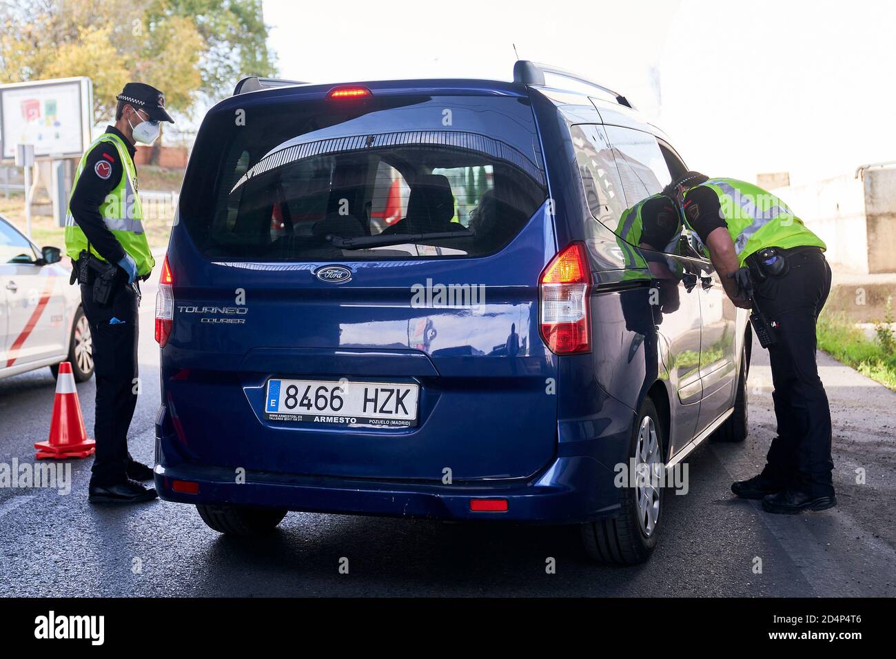 Des policiers demandant la documentation d'un conducteur à un contrôle routier à la sortie de Mostoles.le gouvernement espagnol a déclaré l'état d'alarme après l'échec des négociations avec le gouvernement de la Communauté de Madrid, Cet état d'alarme est donc le moyen de réduire la transmission du virus à Madrid, fermant 10 municipalités de la région. Banque D'Images