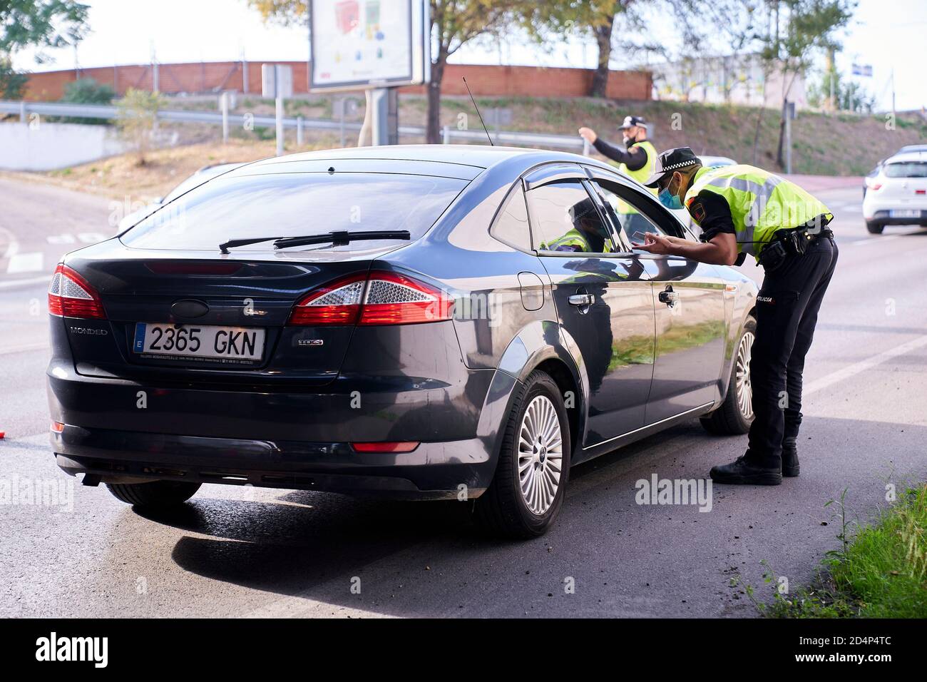 Un policier demandant la documentation d'un conducteur et le contrôle routier à la sortie de Mostoles.le gouvernement espagnol a déclaré l'état d'alarme après l'échec des négociations avec le gouvernement de la Communauté de Madrid, Cet état d'alarme est donc le moyen de réduire la transmission du virus à Madrid, fermant 10 municipalités de la région. Banque D'Images