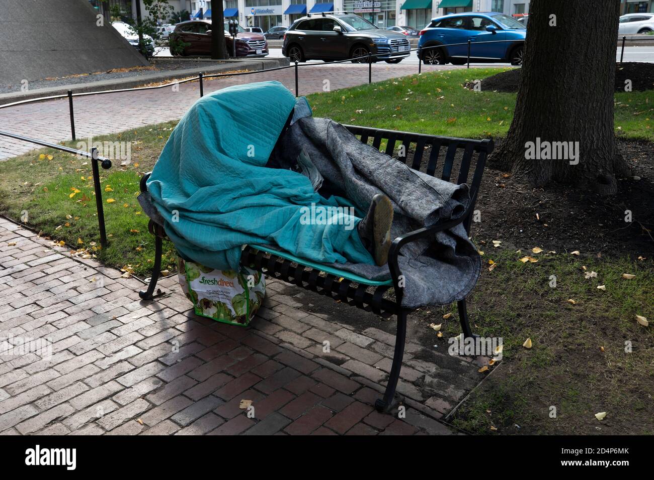 Personne sans abri enveloppée dans un banc de parc de couvertures Boston Massachusetts Banque D'Images