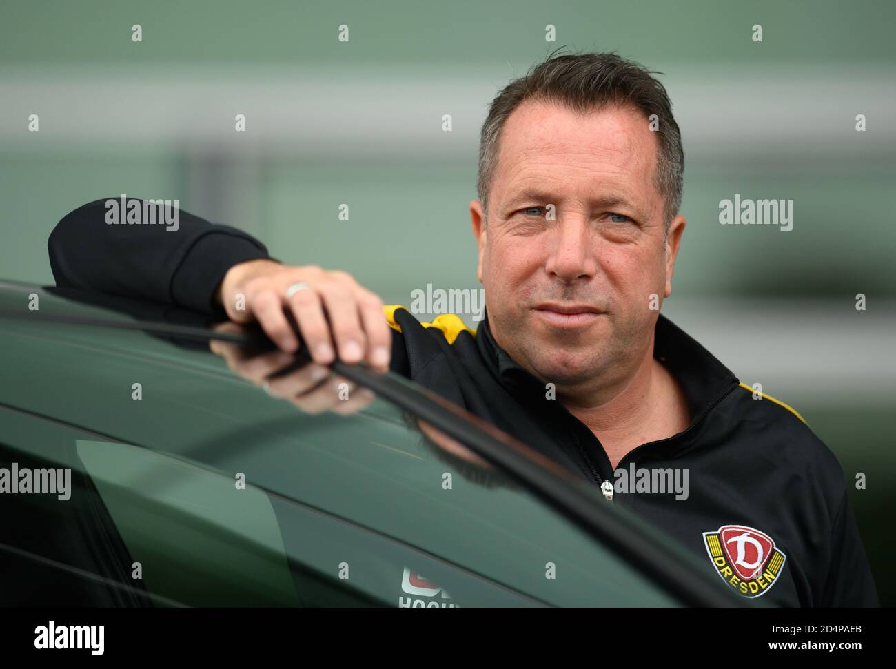 Dresde, Allemagne. 09e octobre 2020. Football: 3ème ligue, conférence de presse pour le 4ème jour d'allumette avant le SG Dynamo Dresden - 1er match du FC Magdeburg au transparent VW Manufactory. L'entraîneur de dynamos Markus Kauczinski est debout à un VW ID.3 pendant un rendez-vous de P.R. Credit: Robert Michael/dpa-Zentralbild/dpa/Alay Live News Banque D'Images