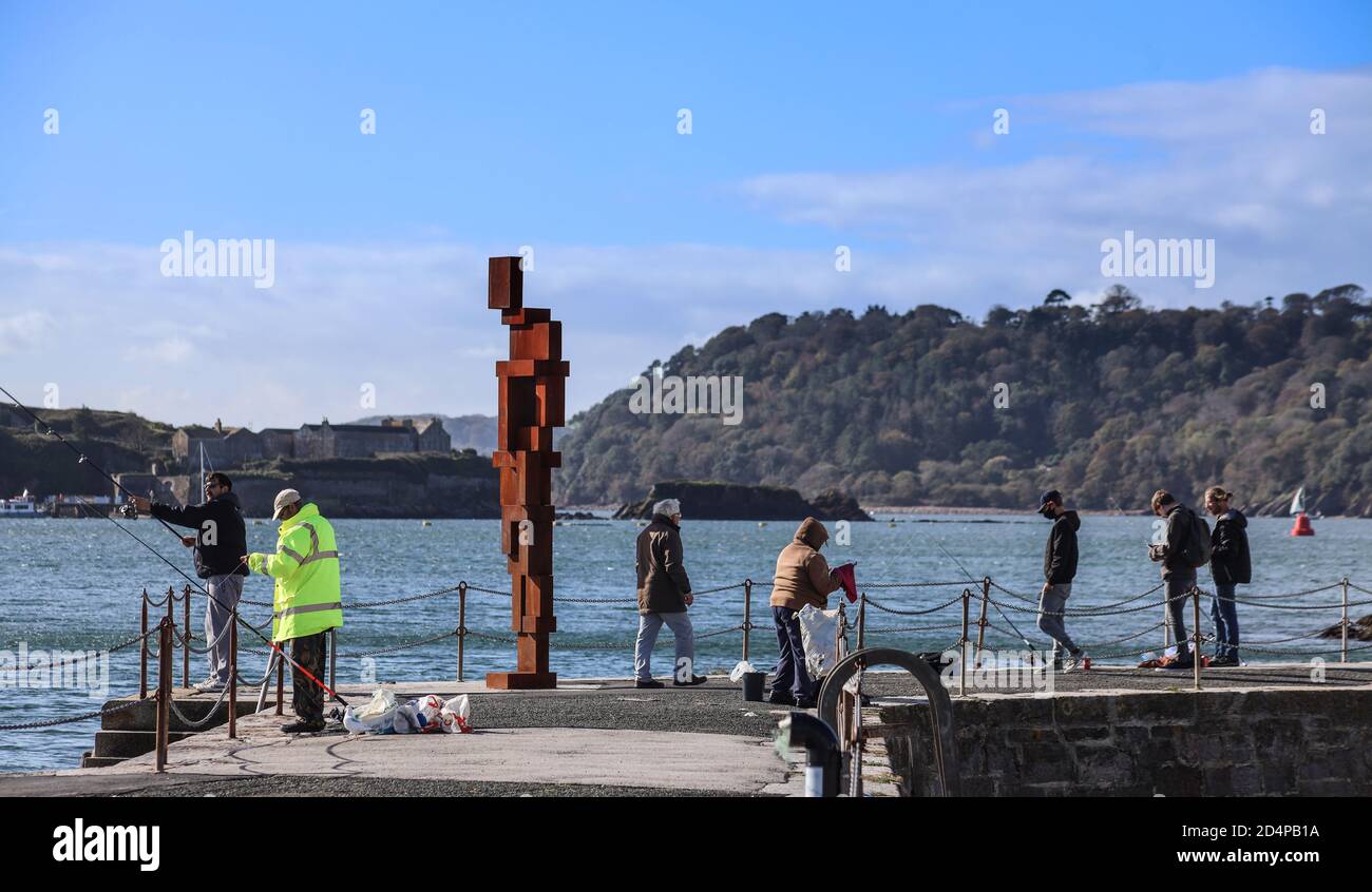 Ignoré par l’activité de pêche du local, le regard de Sir Anthony Gormley II’ 12ft sculpture fait encore une figure frappante à son Maison sur West Hoe Pier Plymouth Banque D'Images