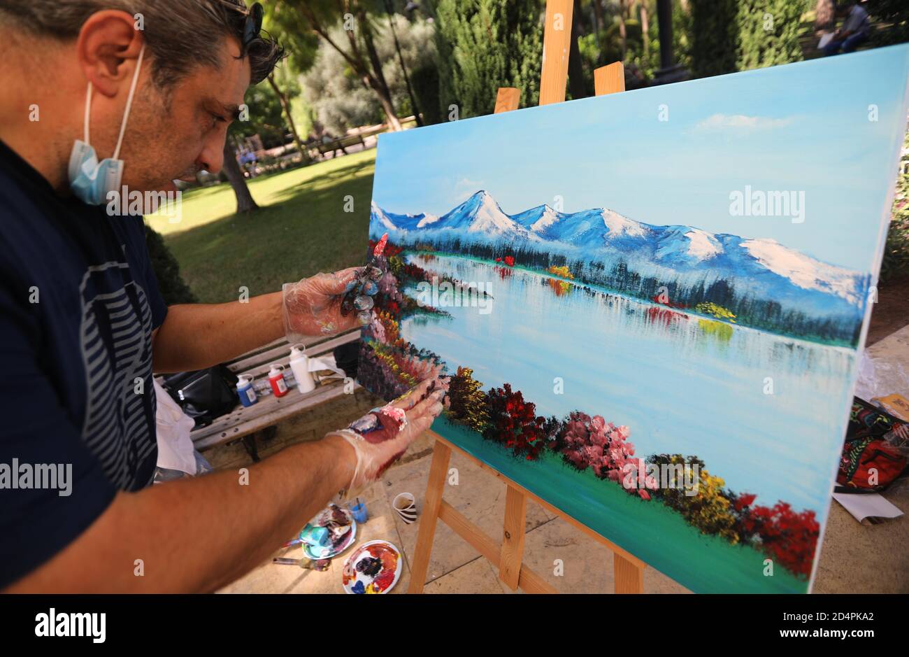 Beyrouth. 10 octobre 2020. Un peintre travaille lors d'une exposition de peintures et de sculptures au Parc Sanayeh à Beyrouth, Liban, le 10 octobre 2020. Le produit de l'exposition sera utilisé pour aider les familles touchées par les explosions du port de Beyrouth. Credit: Bilal Jawich/Xinhua/Alay Live News Banque D'Images