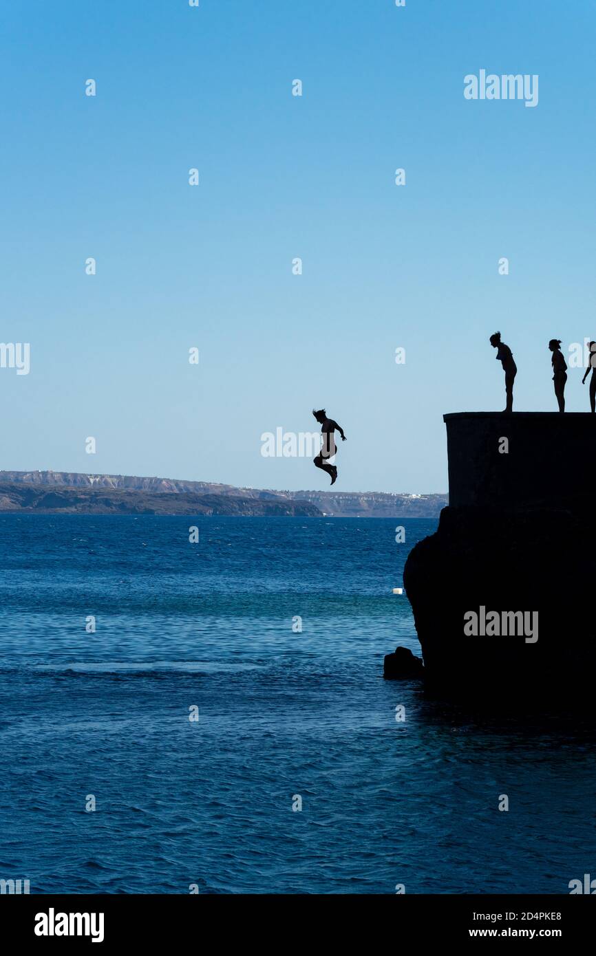 Groupe d'amis sautant dans la mer méditerranée depuis la falaise Banque D'Images