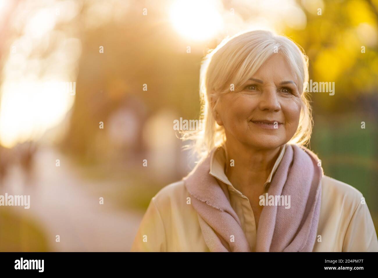 Femme sénior aux couleurs de l'automne au coucher du soleil Banque D'Images