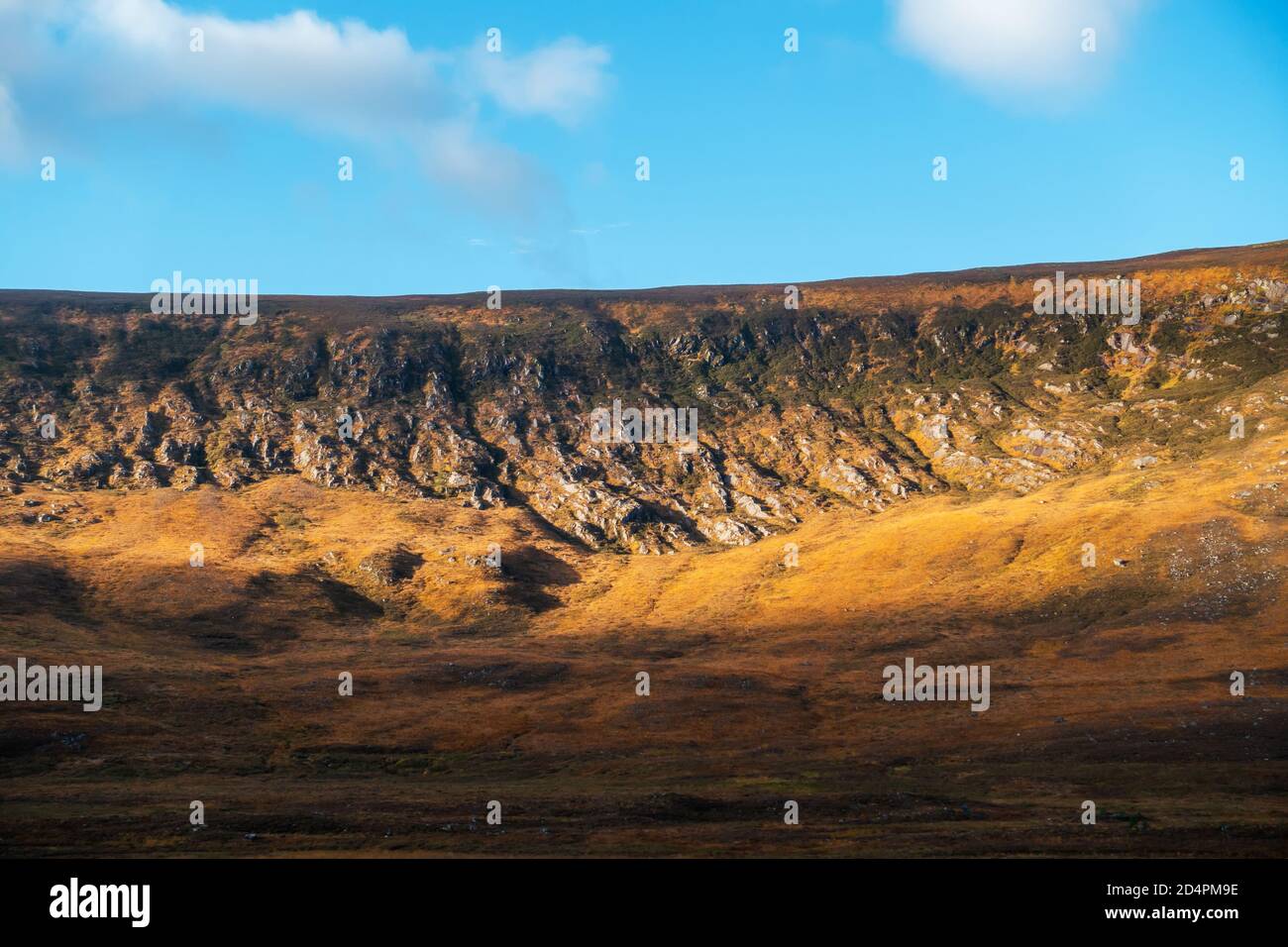 Tôt le matin, le soleil brille à travers les rochers montrant les contours sur une colline écossaise. Banque D'Images