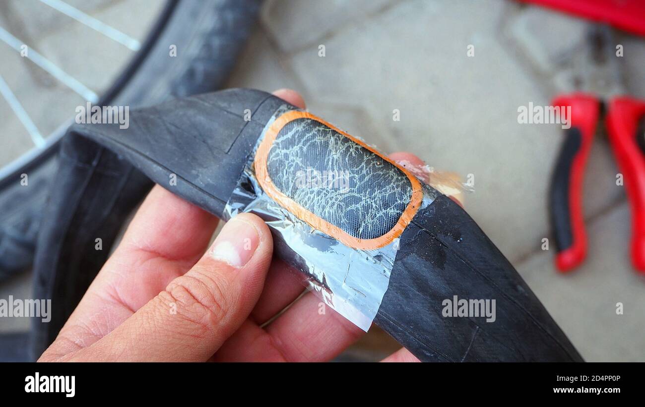 faire la réparation des pneus de vélo, une personne est en train de réparer  une crevaison des chambres à air de vélo Photo Stock - Alamy