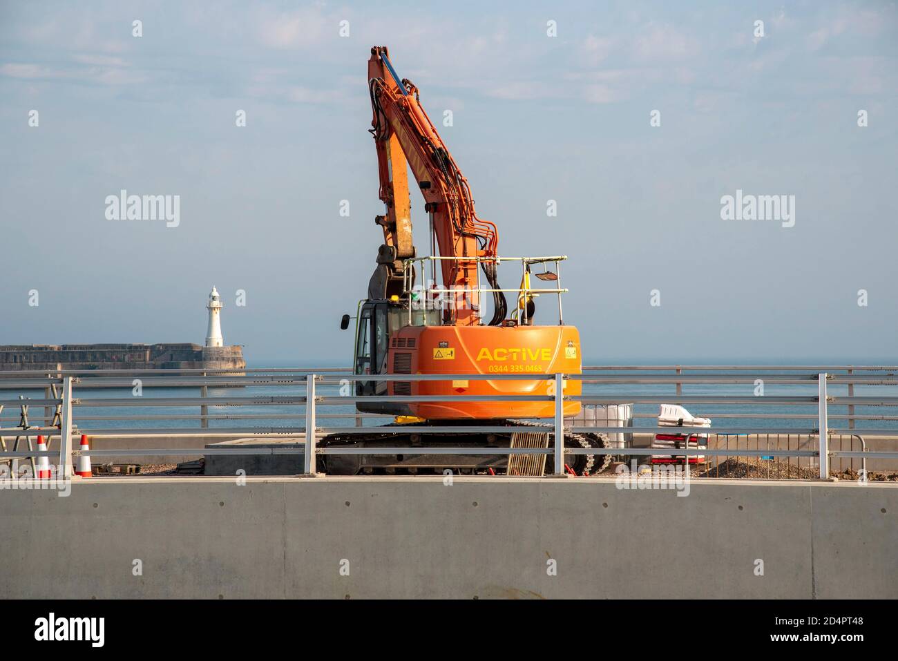 Dover, Kent, Angleterre, Royaume-Uni. 2020. Travaux de génie civil effectués au port de Douvres à l'aide d'une pelle hydraulique avec une toile de fond de l'entrée du port. Banque D'Images