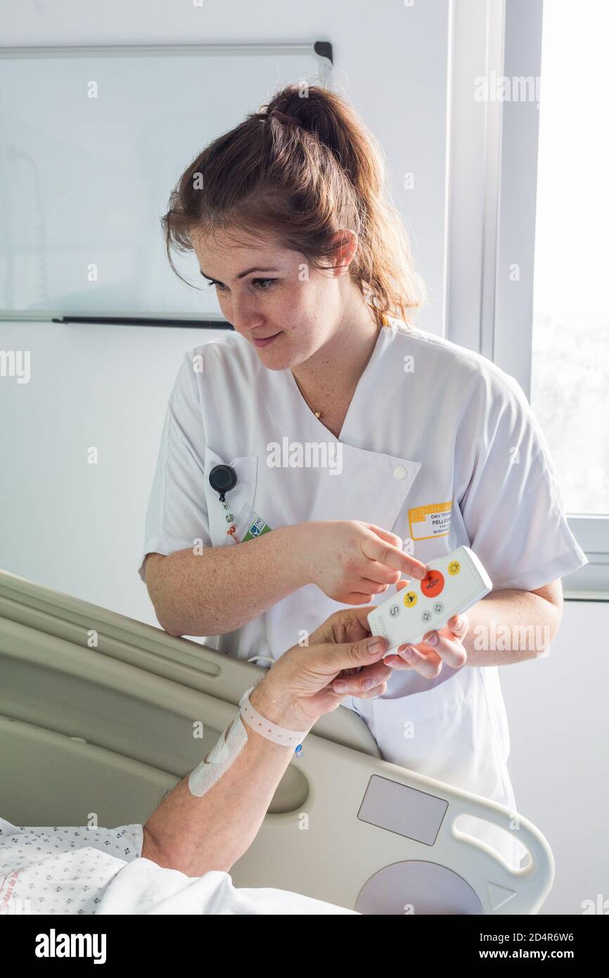 Homme dans la chambre d'hôpital, infirmière à distance, hôpital de Bordeaux, France. Banque D'Images