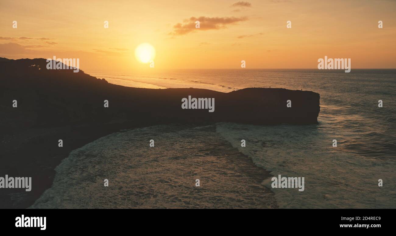 Coucher de soleil avec silhouette de roche à l'océan vue aérienne du golfe. Personne de nature sauvage paysage au soleil couchant la lumière. Paysage marin épique sur la rive de l'île de Sumba, en Indonésie, en Asie. Prise de vue en douceur au cinéma Banque D'Images