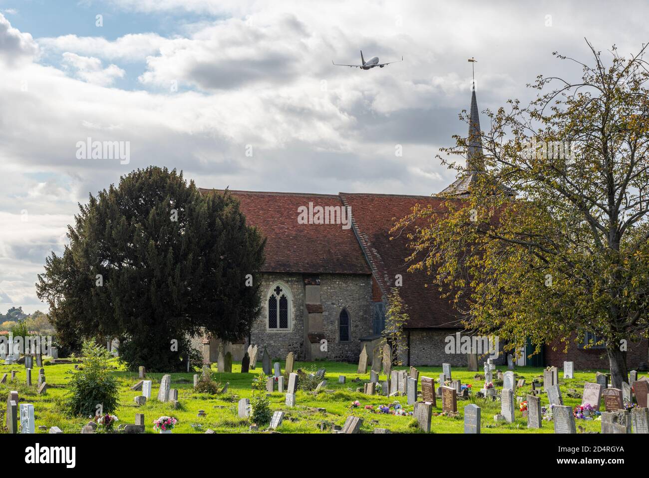 Avion Ryanair Jet Airliner survolez l'église St Laurence et All Saints, Eastwood, Southend on Sea, Essex, Royaume-Uni, sur des tombes. Cimetière. Sinistre Banque D'Images