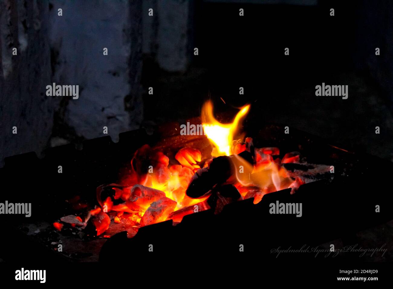 Combustion de charbon avec des flammes jaunes dans la nuit Banque D'Images