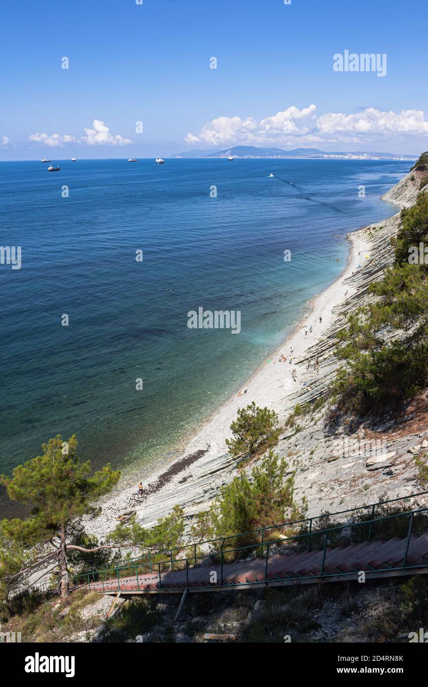 Un escalier menant à la mer sur les rochers mène à une plage sauvage. Vue de dessus de la plage et des cargos en mer. La périphérie de la station de Gelendzhik Banque D'Images