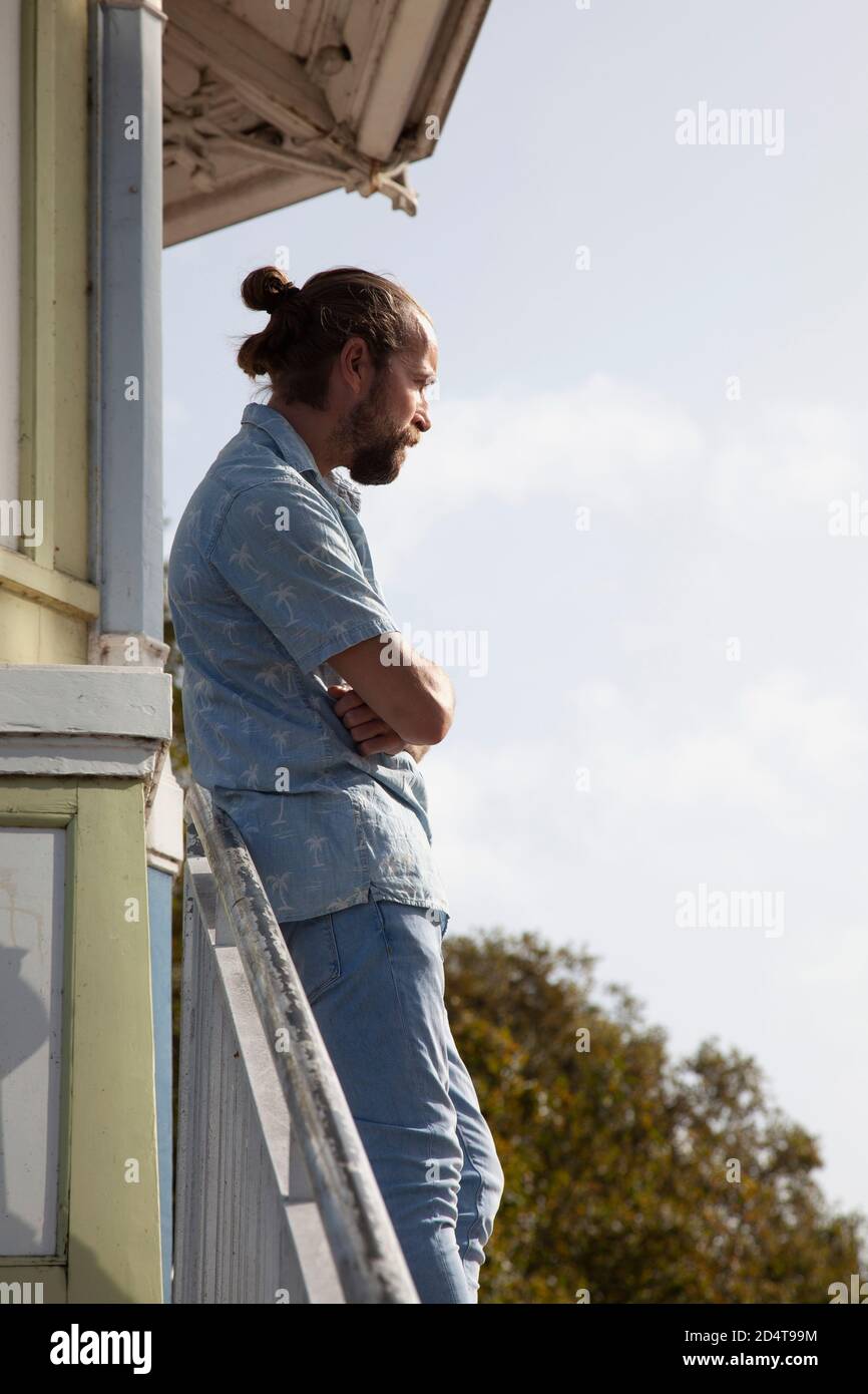 Homme barbu à manches courtes et Jean debout près des balustrades Banque D'Images