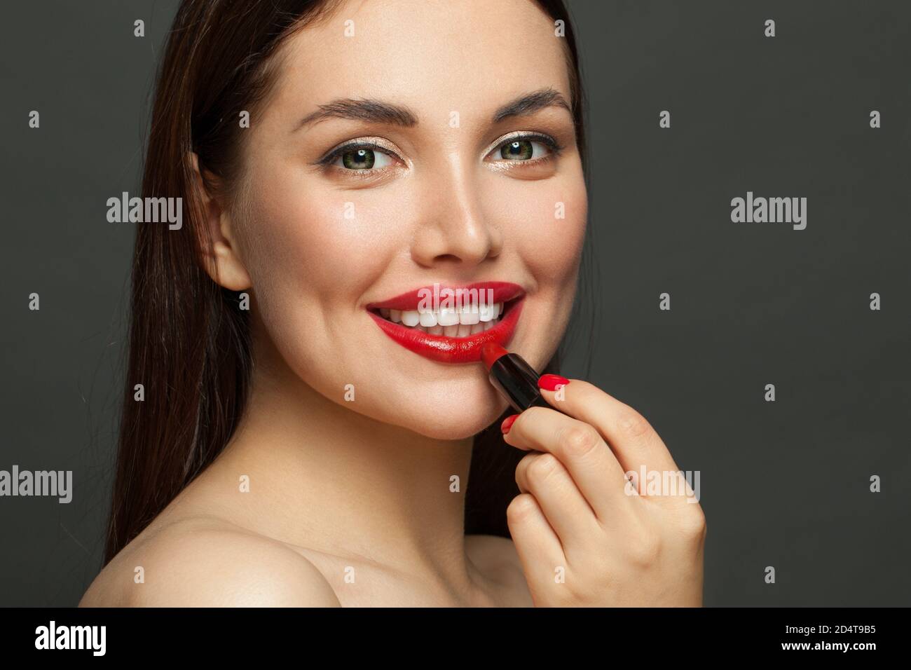 Jolie femme visage avec des lèvres rouges brillantes et rouge à lèvres sur  arrière-plan noir Photo Stock - Alamy