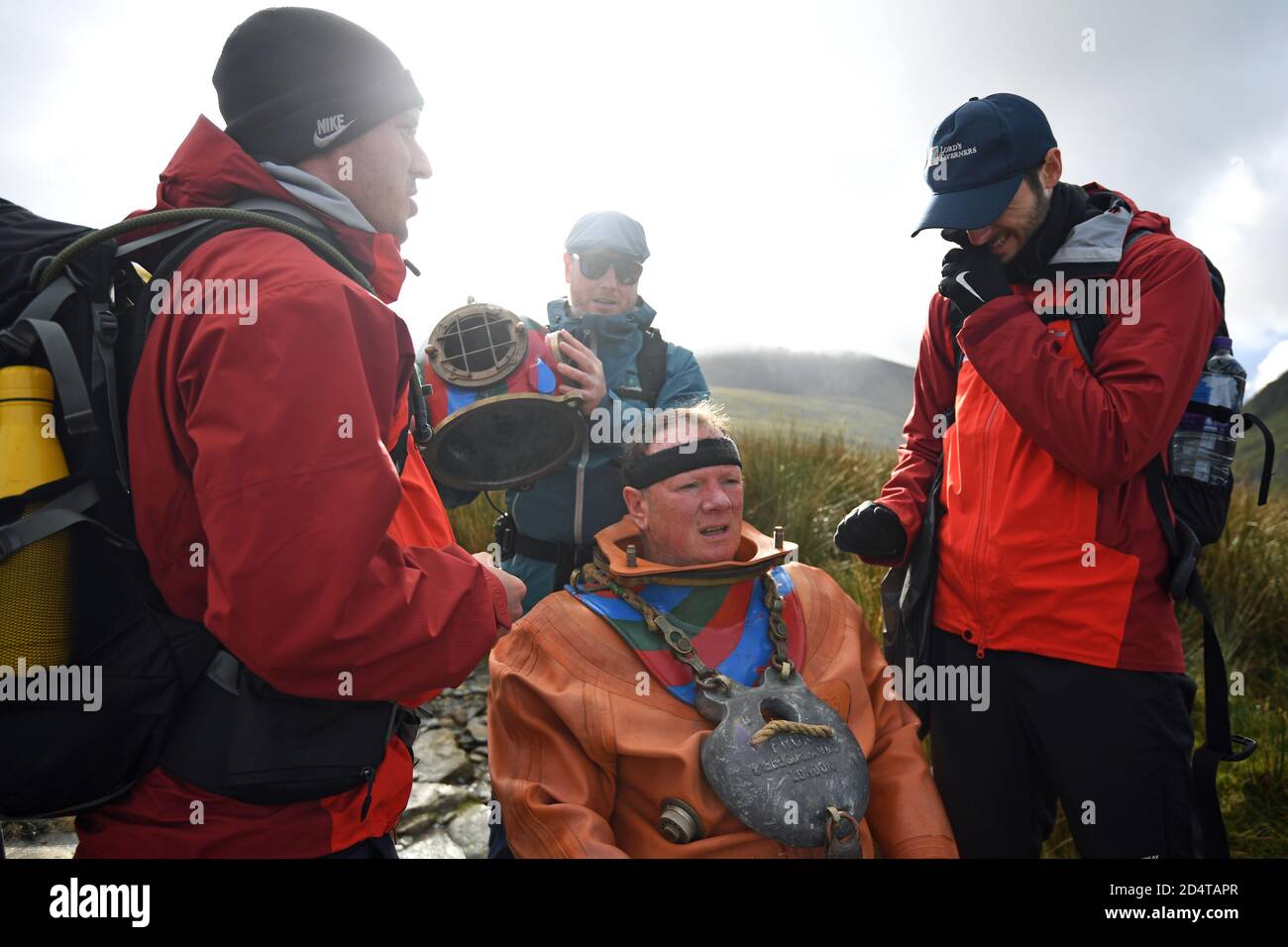 Lloyd Scott, collecteur de fonds vétéran, qui tente de grimper les trois sommets en aide à la charité de Lord's Taverners tout en portant un costume de plongée en haute mer lors de son défi sur le dernier pic, Mount Snowdon à Snowdonia, au nord du pays de Galles. Banque D'Images