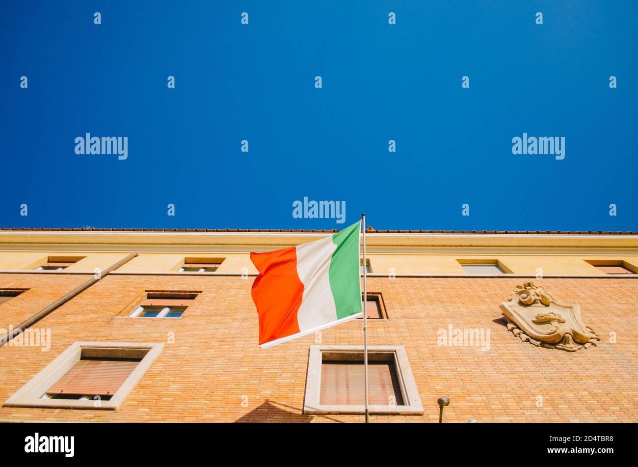 Rome, Italie - UNE vue minimaliste supérieure d'un drapeau italien se déplaçant à gauche et attaché à un poteau dans un appartement résidentiel avec un ciel clair dans le TH Banque D'Images