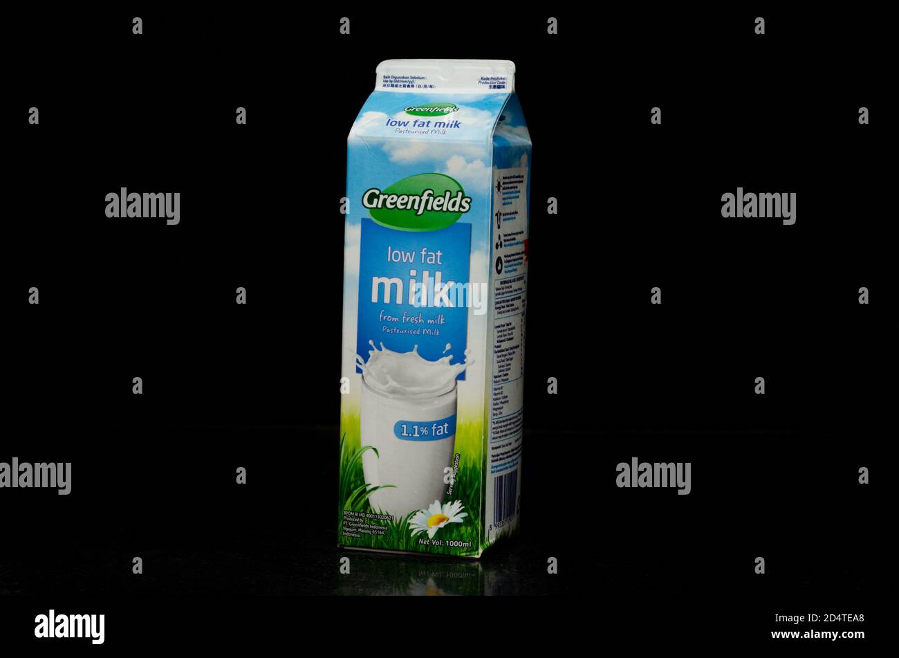 Vue à gauche d'un litre de boîte de lait à faible teneur en matières grasses provenant de la marque Greenfields originaire de Malang, Indonésie, isolée sur fond noir. Banque D'Images