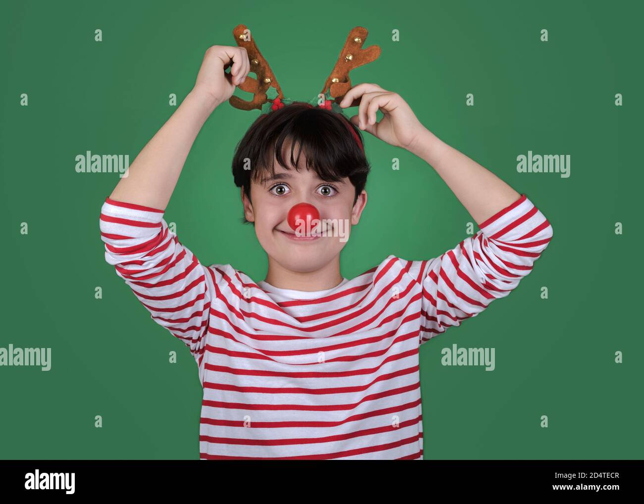 Joyeux Noël, drôle d'enfant dans un costume de noël de renne de Rudolph plus arrière-plan vert Banque D'Images