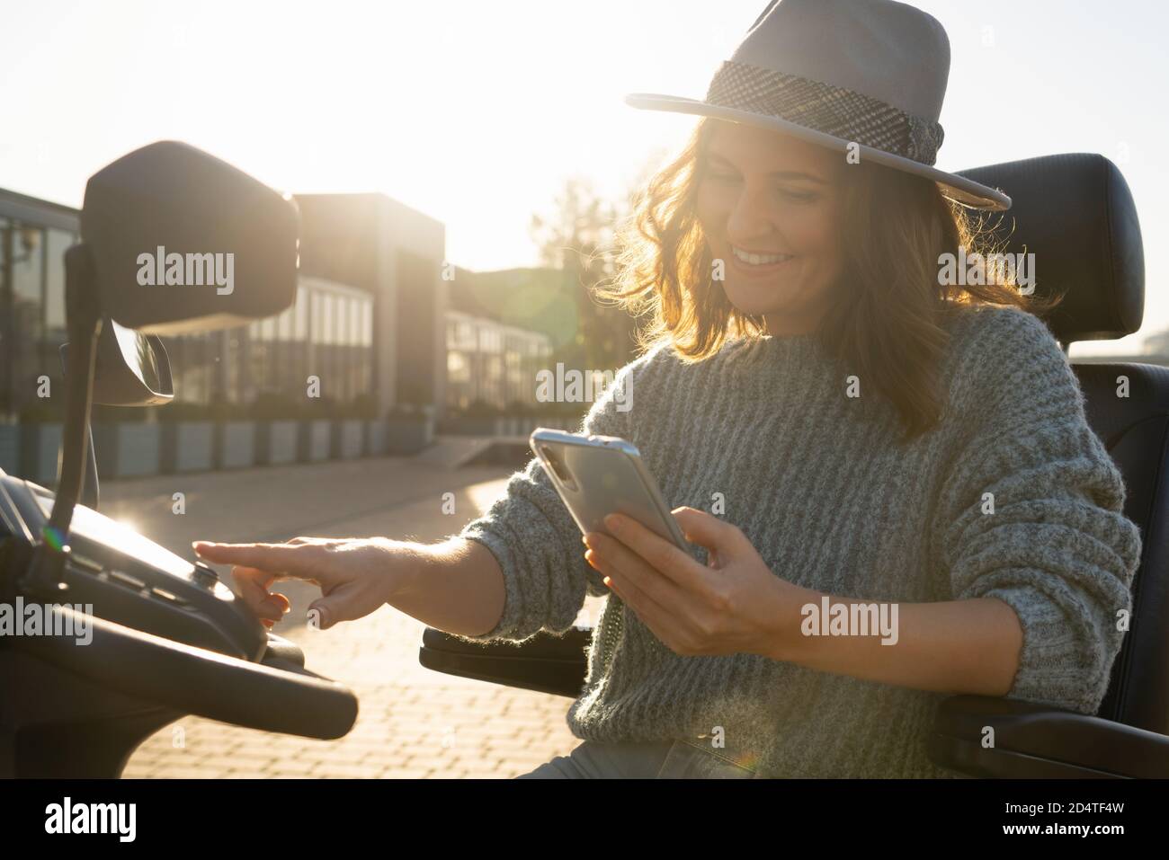 Femme touriste à bord d'un scooter électrique à quatre roues sur une rue de la ville. Banque D'Images
